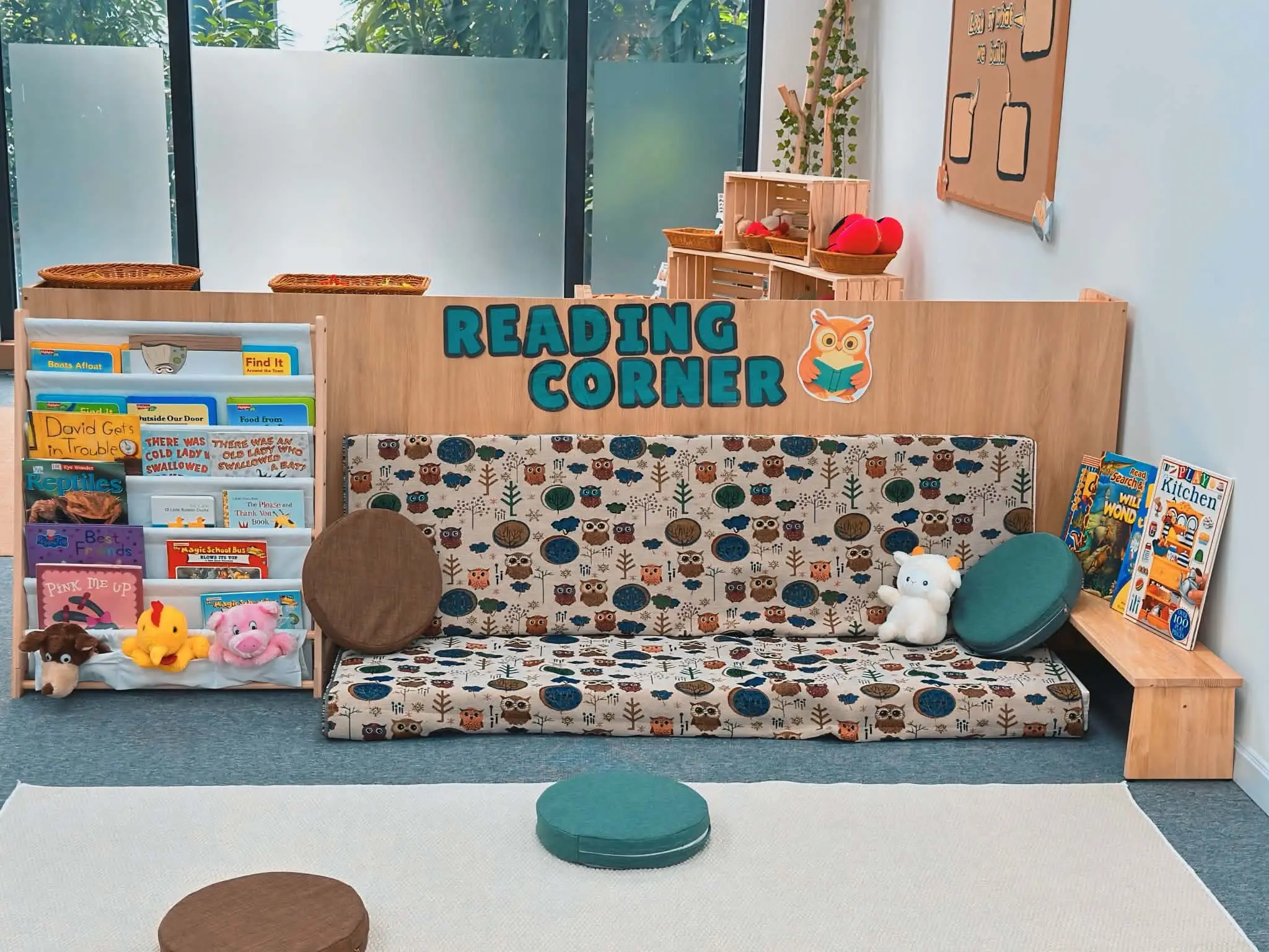 Reading corner with owl-print cushions and book shelf